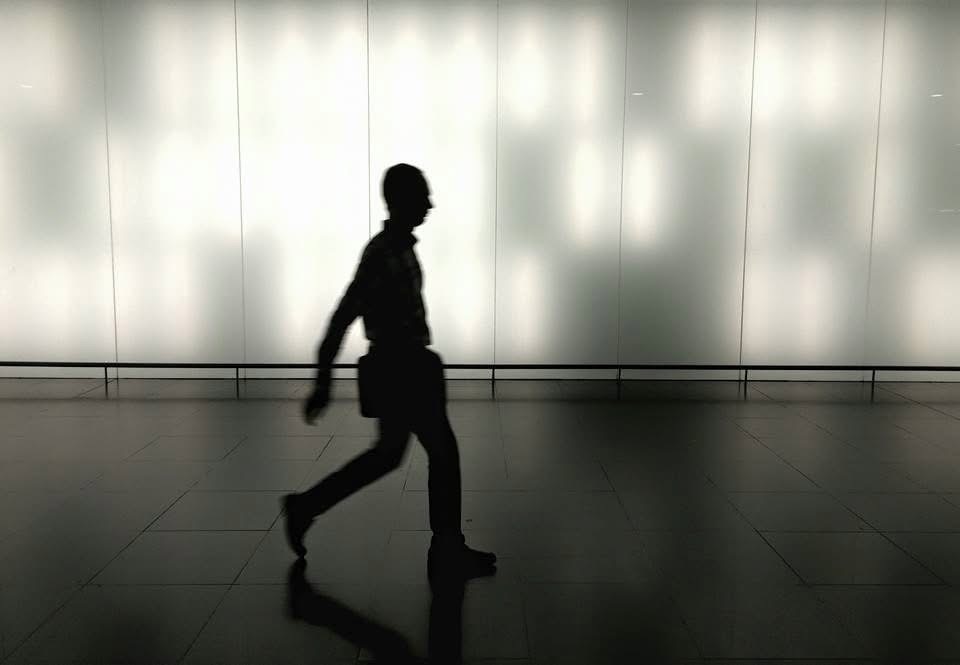 Original logo photograph — silhouette of a man walking